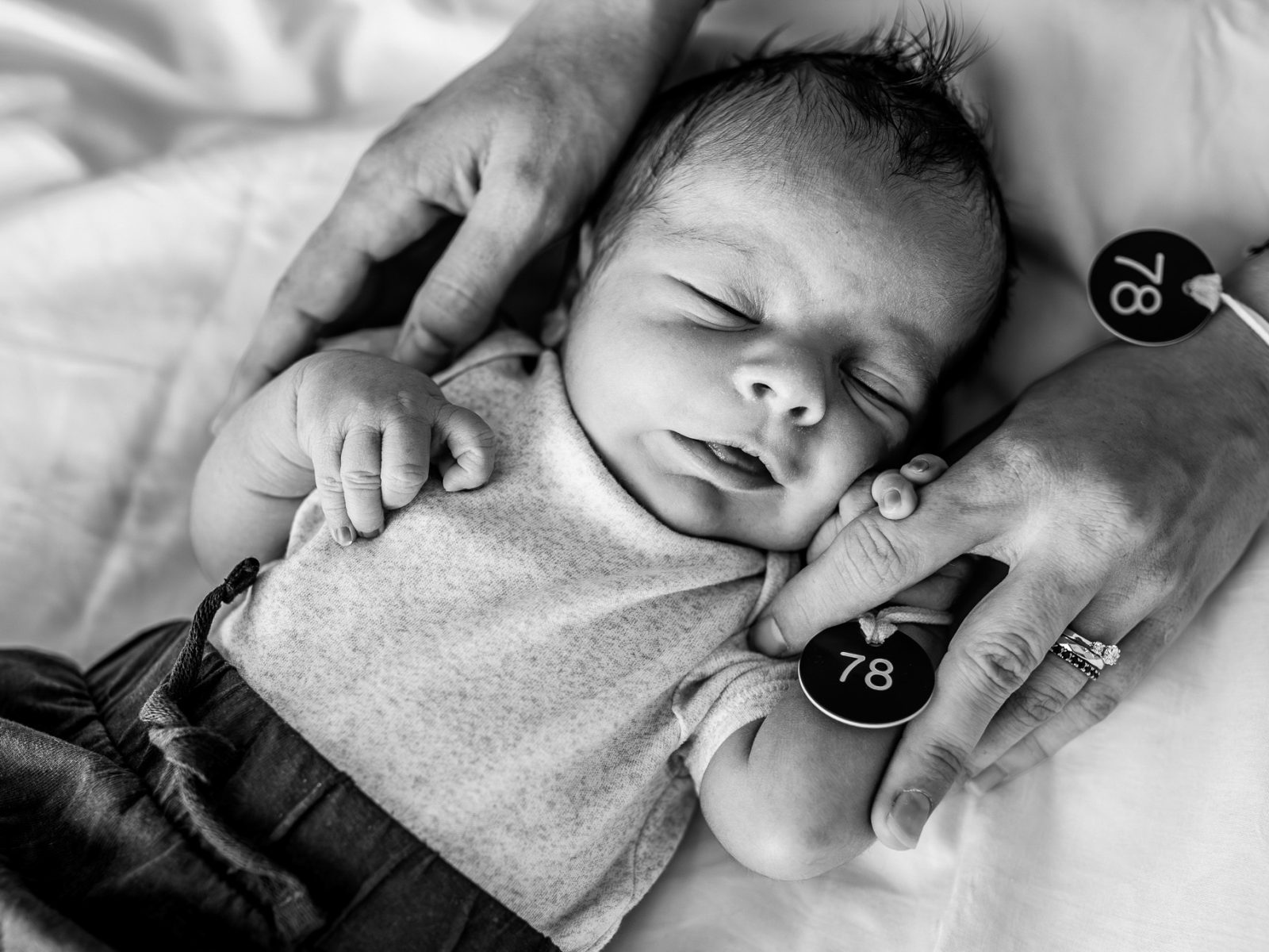 Ruce maminky drží novorozené miminko v porodnici Praha Bulovka